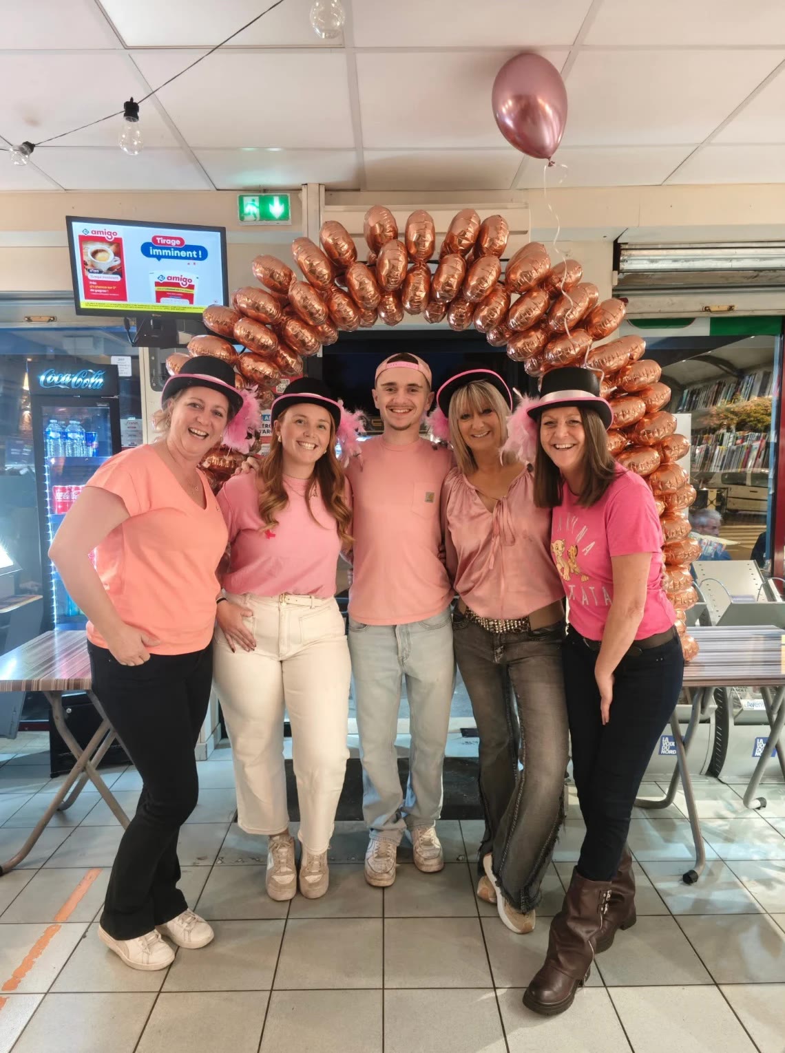 L'équipe du Lav'Entik habillée en rose sous une arche de ballons pour la soirée Octobre Rose