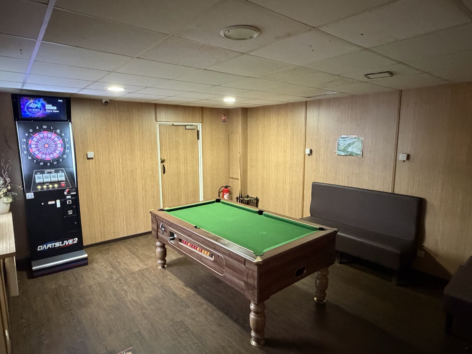 La salle de jeux du Lav'Entik : une table de billard, une cible de fléchettes électronique et une banquette